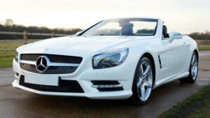 Elegant white Mercedes-Benz convertible on a scenic countryside road in the United Kingdom.