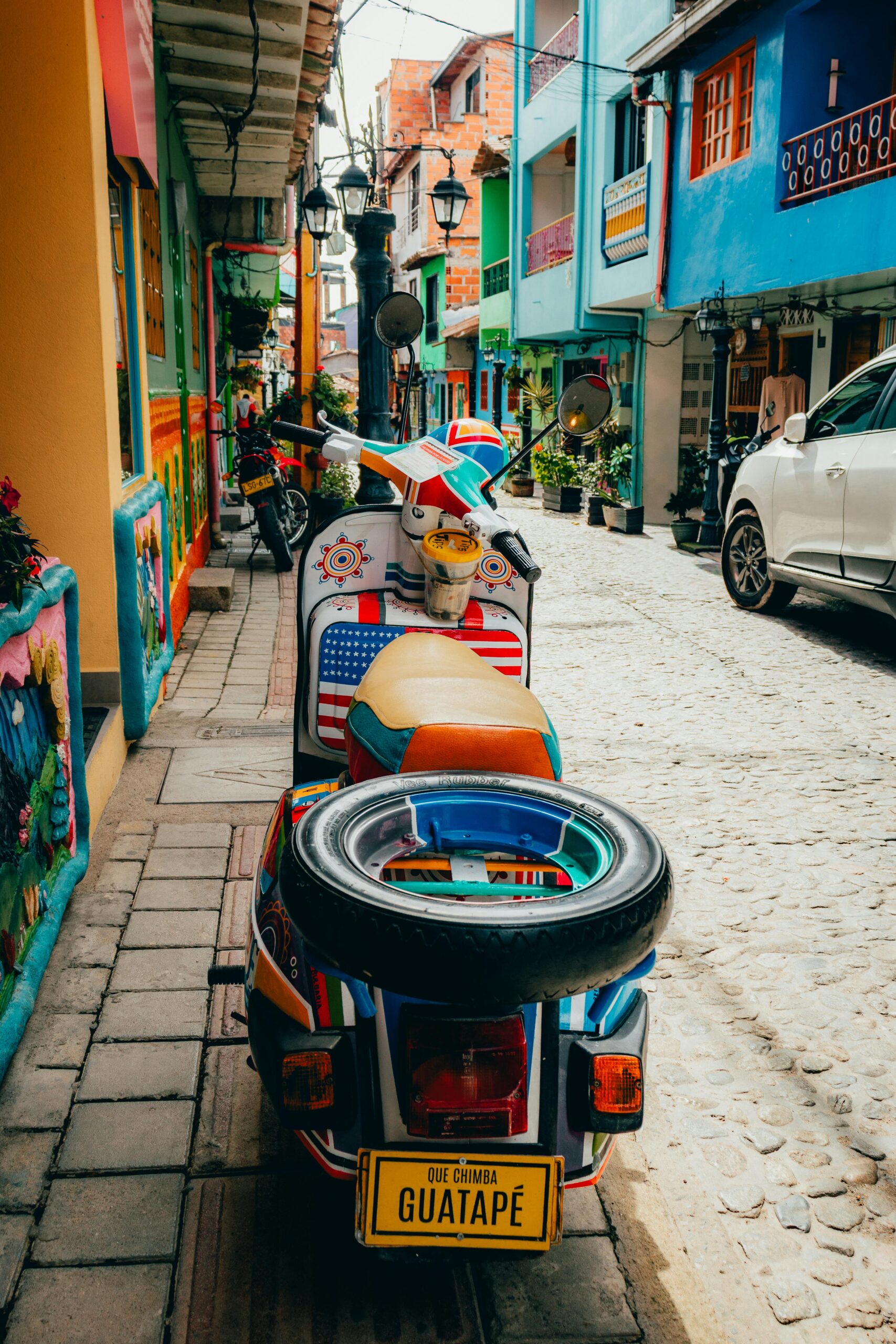 A vibrant scooter on a colorful, picturesque street in Guatapé, Colombia.