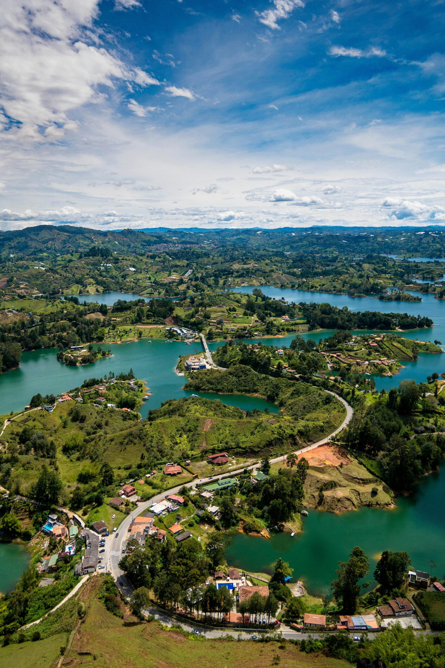 Discover the stunning aerial view of Guatapé, Colombia, showcasing its vibrant lakes, winding roads, and lush greenery.